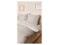 LIVARNO home microvezel jersey hoeslaken op een lichtgrijs bed.