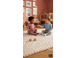 Twee baby's zitten op een vloerkleed en spelen met houten blokken in een kinderkamer.