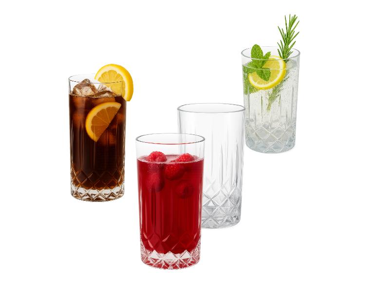 Vier glazen, één met cola, één met frambozendrank, één leeg en één met bruiswater.