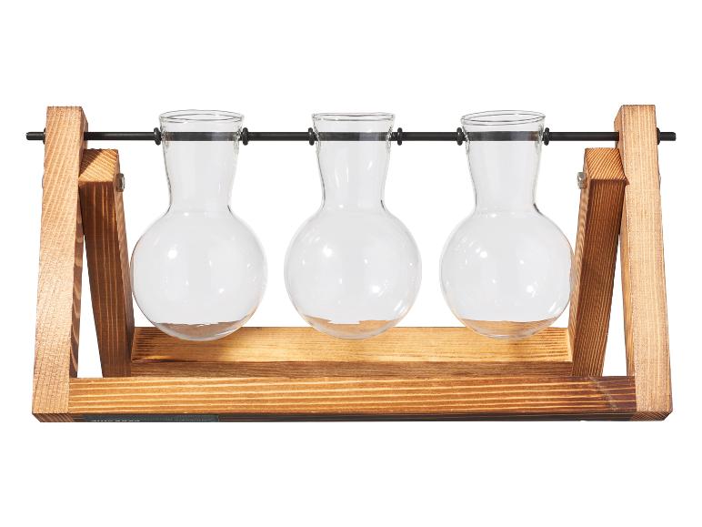 Houten plantenvermeerderingsstation met drie glazen vazen