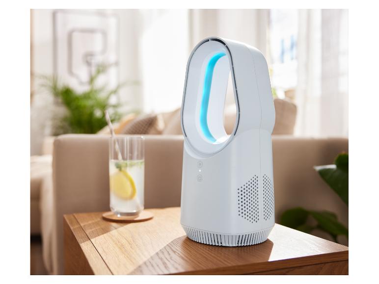 TRONIC® Mini-tafelventilator met blauw licht op een houten tafel naast een drankje.