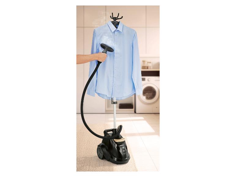 Man stoomt een blauw overhemd met een kledingstomer in de wasruimte.