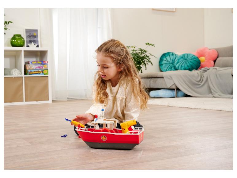 Een meisje speelt met een Playmobil speelgoedboot.