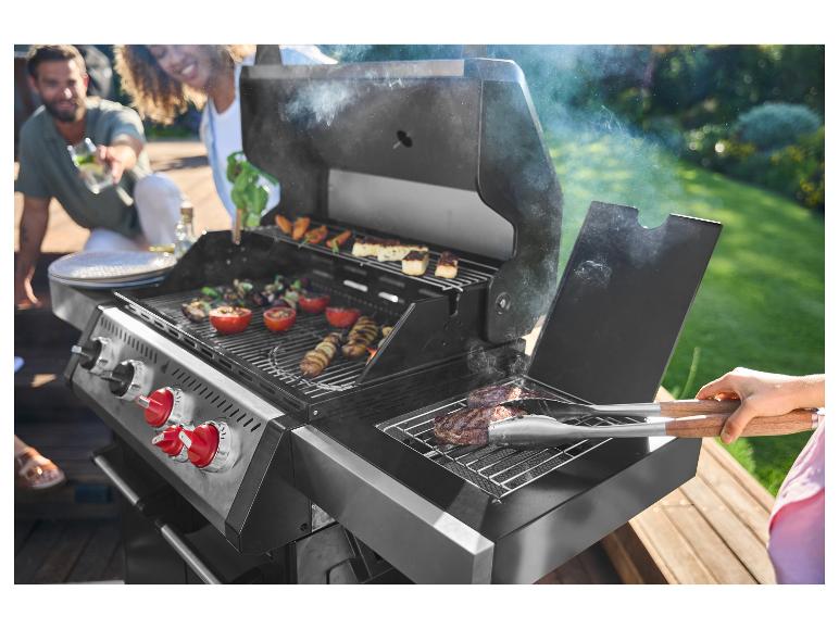 Gasbarbecue met vrienden, vlees en groenten grillend.