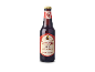 Een fles donker kloosterbier met een rood etiket.