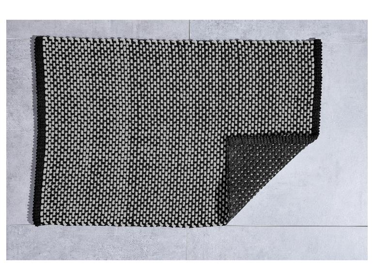 Grijs en zwart badmat met geweven textuur.