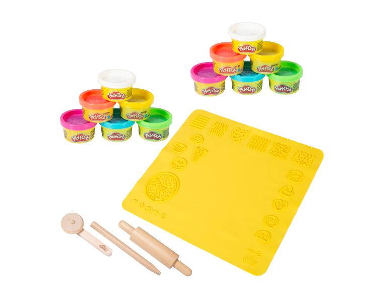 Kleurrijke kleipotjes, een gele speelmat met vormen en houten gereedschap.