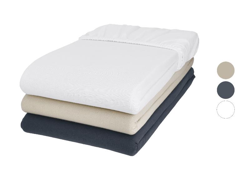 Set van drie hoeslakens in wit, beige en donkergrijs.