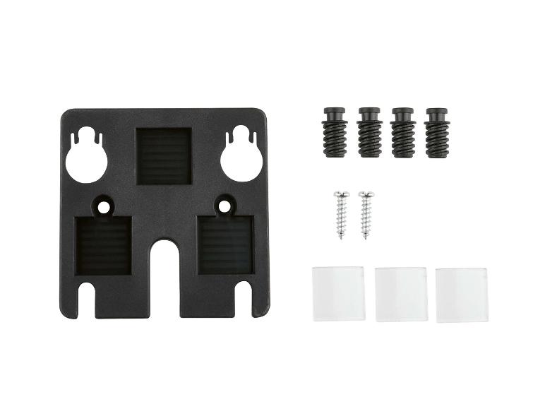 Een zwarte plastic montageplaat met schroeven, pluggen en afstandhouders.