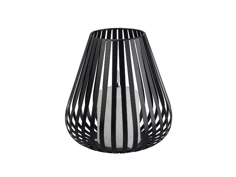 Een zwarte metalen kaarshouder met een witte kaars.