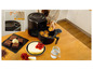Een Tefal Airfryer met muffins, brownies, cheesecake en een kan water op een houten tafel.
