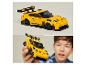 LEGO Speed Champions Porsche 911 GT3 RS speelgoedauto op een tafel en vastgehouden door een kind.