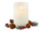 Witte LED-kaars met dennenappels en rode bessen.
