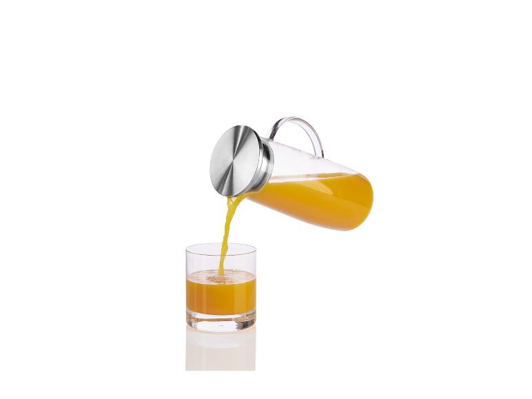 Orangensap wordt gegoten uit een glazen kan in een glas.