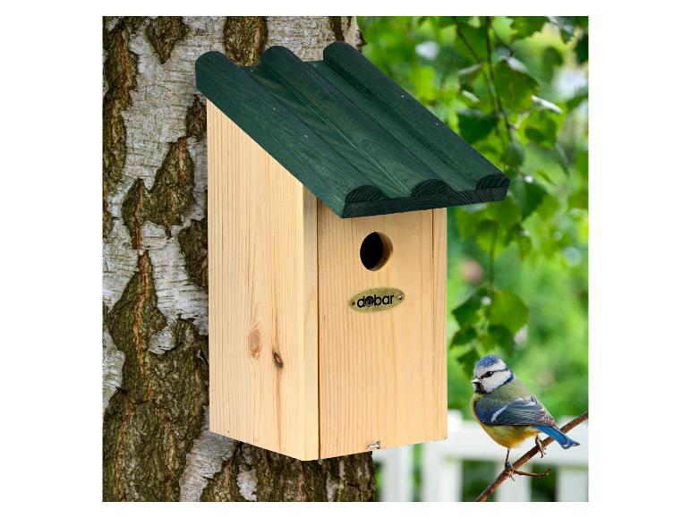 Licht houten vogelhuisje met groen dak, bevestigd aan een boom, met een pimpelmees op een tak.
