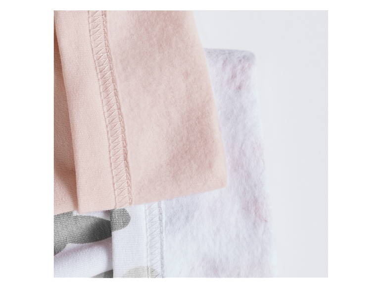 Zachte gebreide stoffen in roze en grijze tinten.