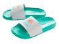 Twee turquoise slippers met een witte band en een kleurrijk zon- en golfpatroon.