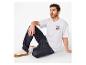 Man in wit T-shirt met nummer 23 en donkere jeans, zittend op de grond.