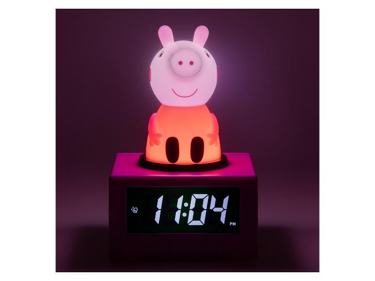 Lichtgevende wekker in de vorm van een varken, toont 11:04 PM.