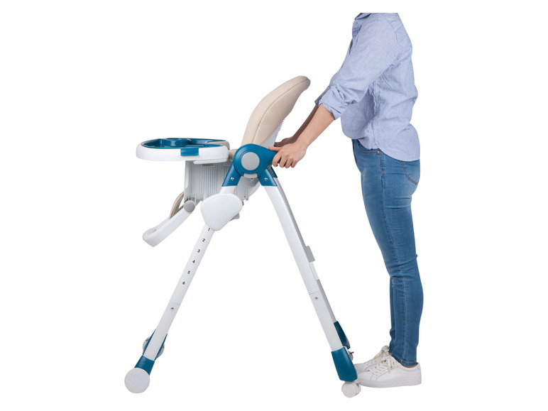 Een persoon die een blauwe en witte babystoel verplaatst.