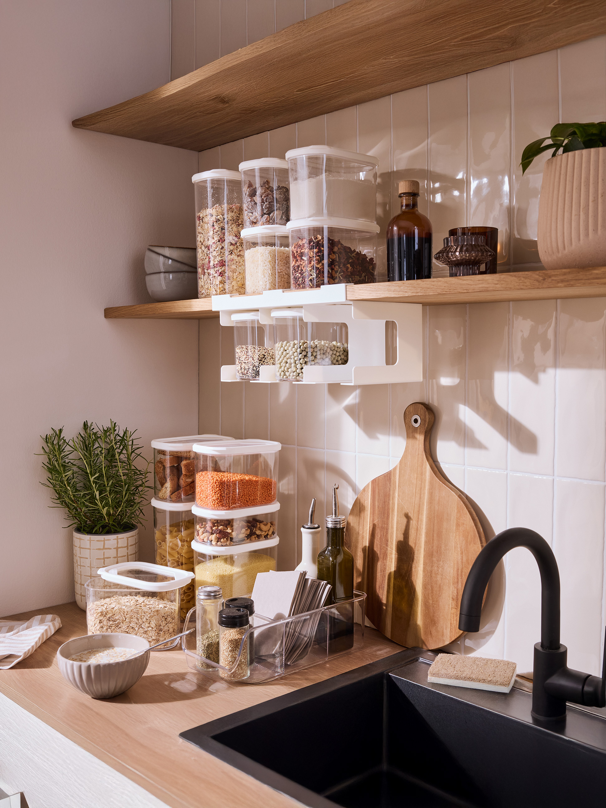 Keuken met open planken, transparante voedselcontainers en houten accessoires.