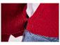 Rood gebreid vest met knopen, gedragen over een wit T-shirt en jeans.