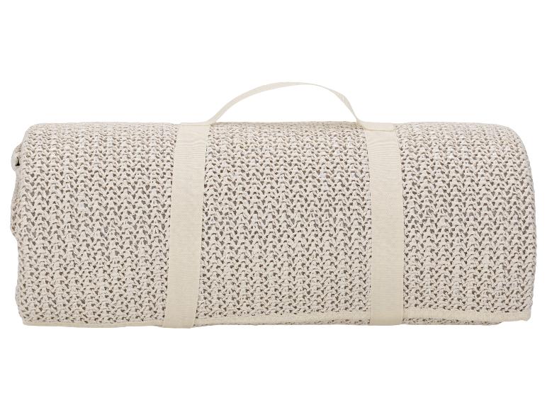 Opgerolde beige strandmat met handvat.