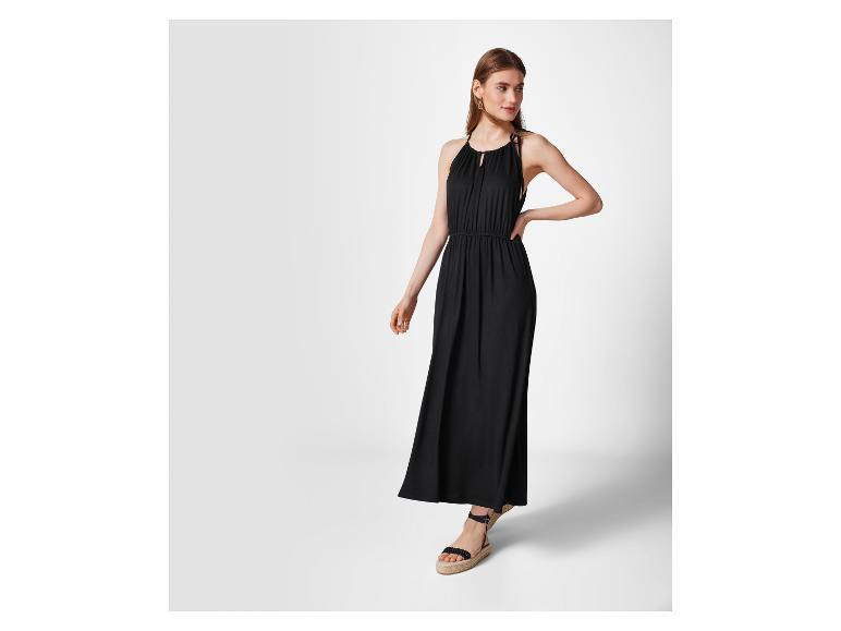 Zwarte maxi jurk en platte sandalen: elegante zomermode.