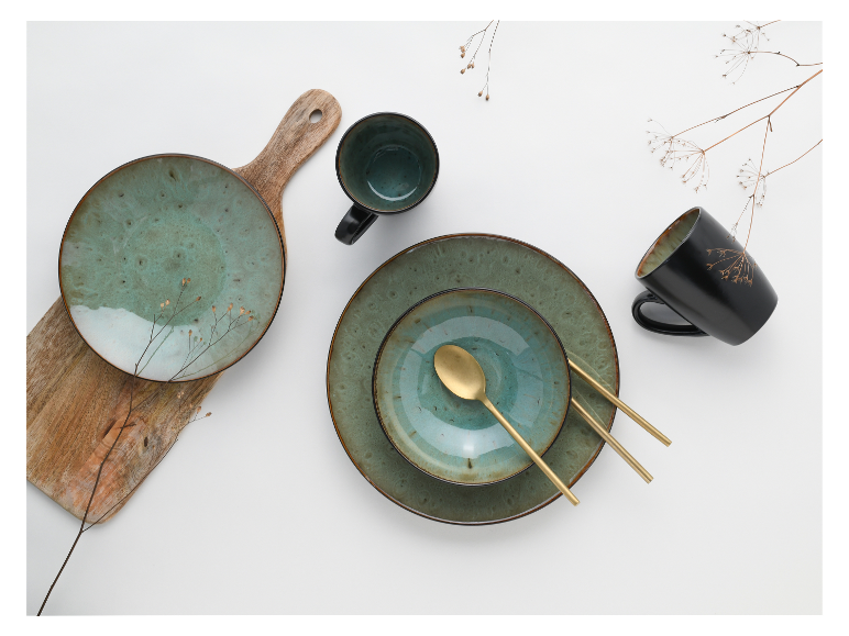 Turquoise en zwarte keramische servies, met gouden bestek.