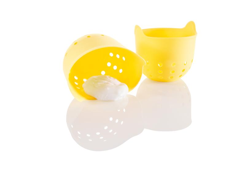 Twee gele eierrekken met een ei in een van de rekken.