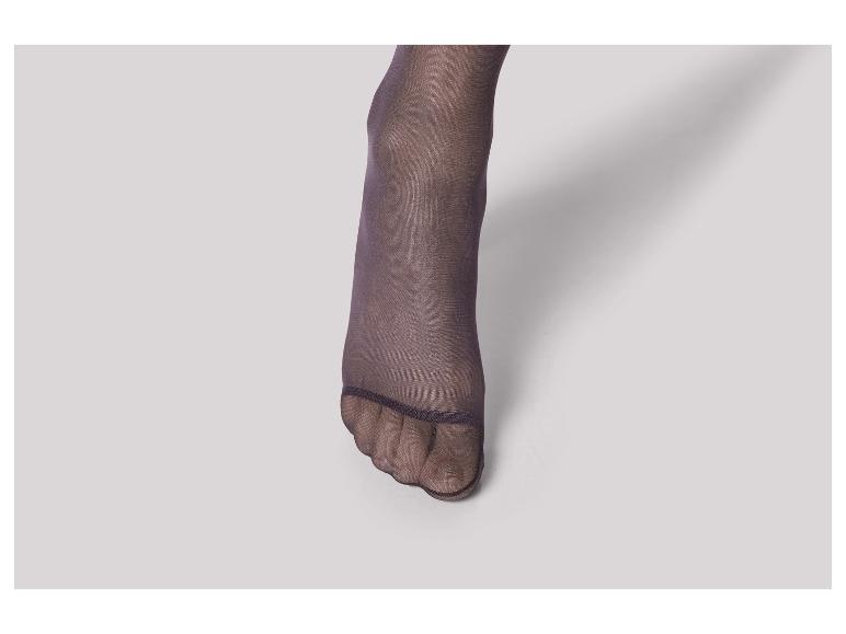 Een close-up van een voet met zwarte panty's.