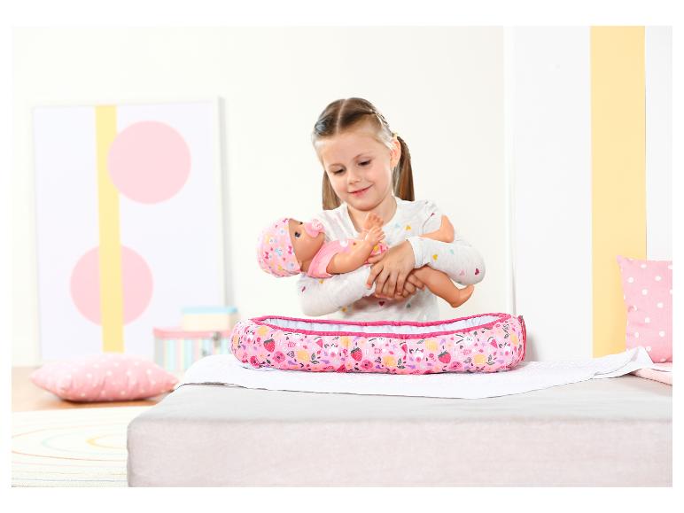 Meisje met pop met speen en fruit-thema poppenbed.