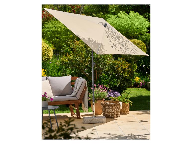 Terrasparasol die schaduw biedt boven een tuinbank en potplanten op een zonnig terras.