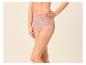 Vrouw draagt roze high-waist slip met kanten details.