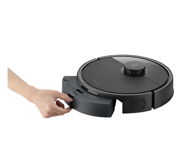 Robotstofzuiger met verwijderbare stofbak, bediend door een hand.