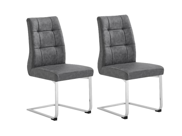Twee grijze stoelen van stof, met verchroomd metalen onderstel.
