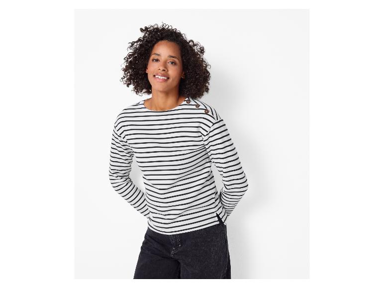 Vrouw in gestreept shirt met lange mouwen en donkere jeans