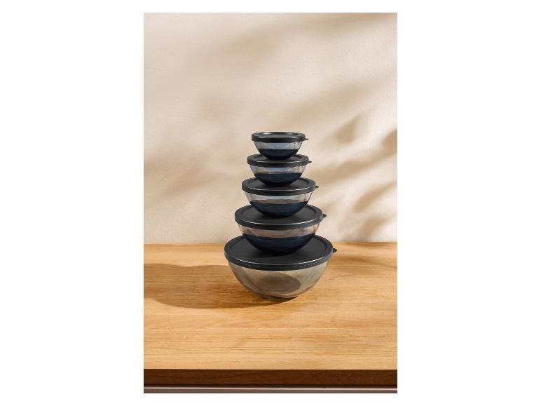 Set van vijf glazen kommen met zwarte deksels, op elkaar gestapeld.