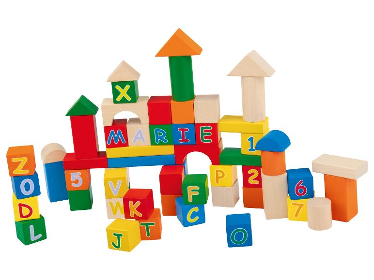 Houten blokken met letters en cijfers, gestapeld in een toren.