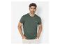 Man in een donkergroen T-shirt met de tekst 'Thrive in the unknown' en een lichte broek.