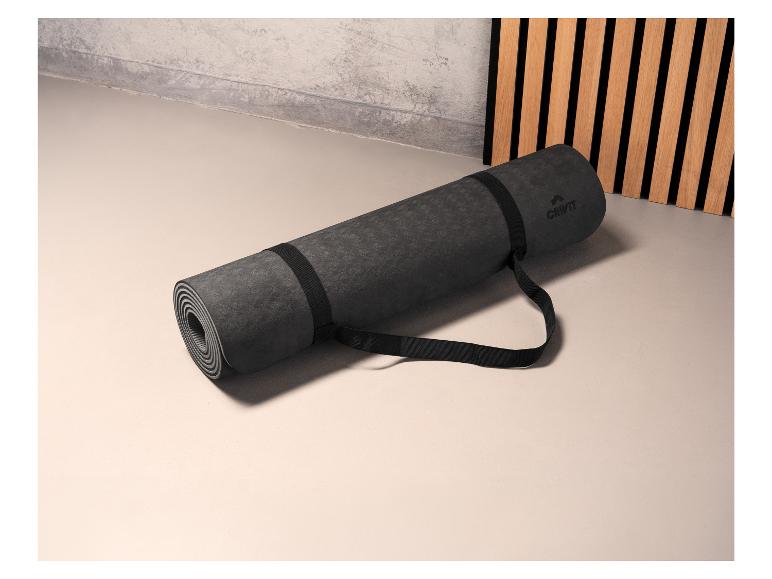 Een opgerolde zwarte yogamat van Crivit met een draagriem.