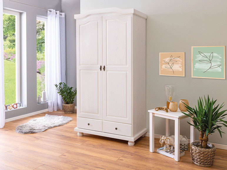 Witte kledingkast met twee deuren en een lade, in een moderne woonkamer.