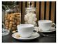 Twee witte koffiekopjes met amaretti en potten met koekjes en marshmallows.