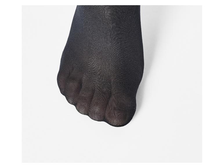 Voet in een zwarte, transparante panty op een witte achtergrond.