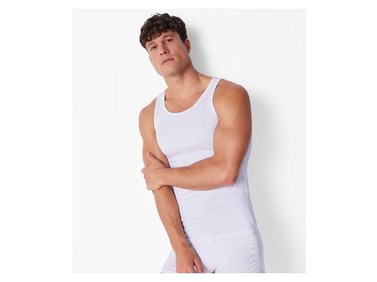 Man in wit tanktop en onderbroek.