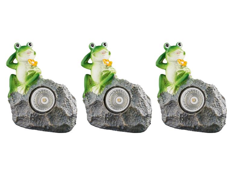 Drie kikker-zonnelampen op een rots.