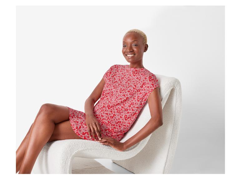 Rode bloemenjurk en een pluche stoel.