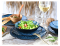 Salade in een kom en getextureerde blauwe borden.
