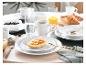 Ontbijttafel gedekt met toast en jam, croissants, bosbessen, koffie en sinaasappelsap.