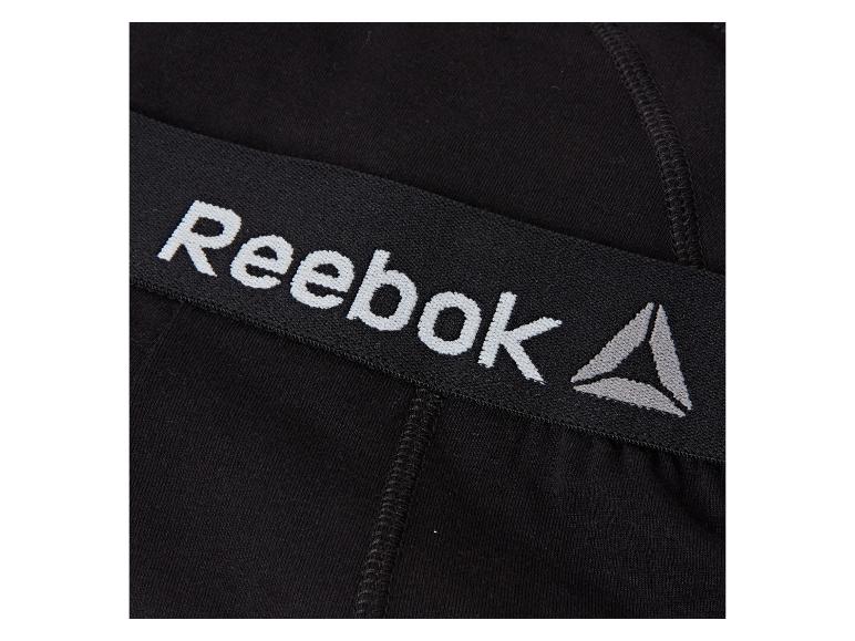 Zwarte elastische band met wit en grijs Reebok-logo op compressieshorts.